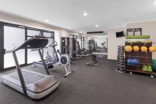 A Room With A Treadmill And Shelves