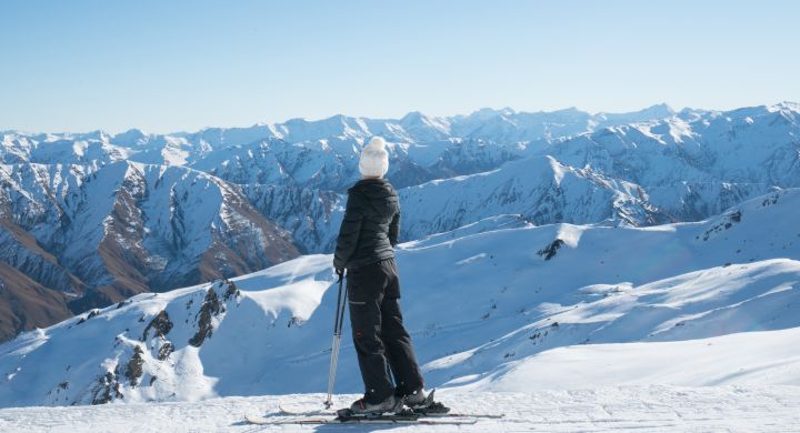 A Man Standing On Top Of A Snow Covered Mountain
