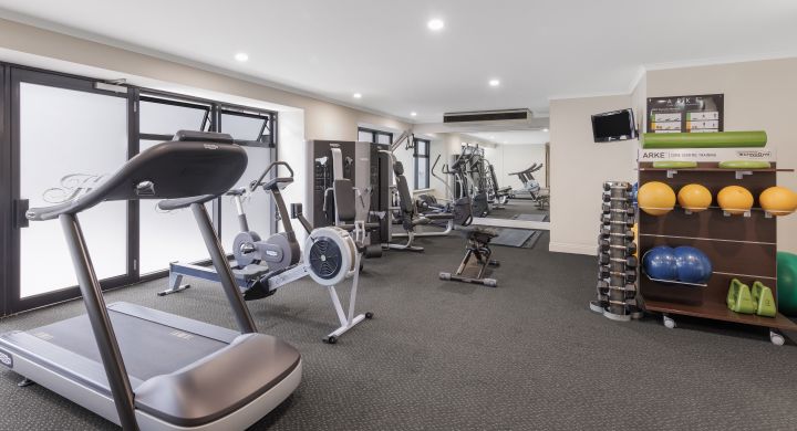 A Room With A Treadmill And Shelves